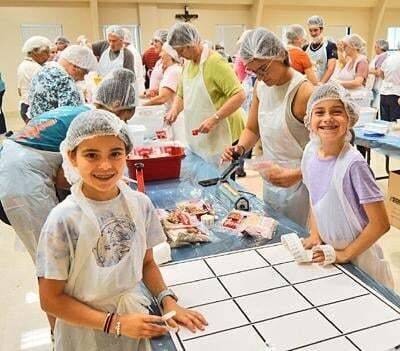 Volunteers pack meals for Cross Catholic