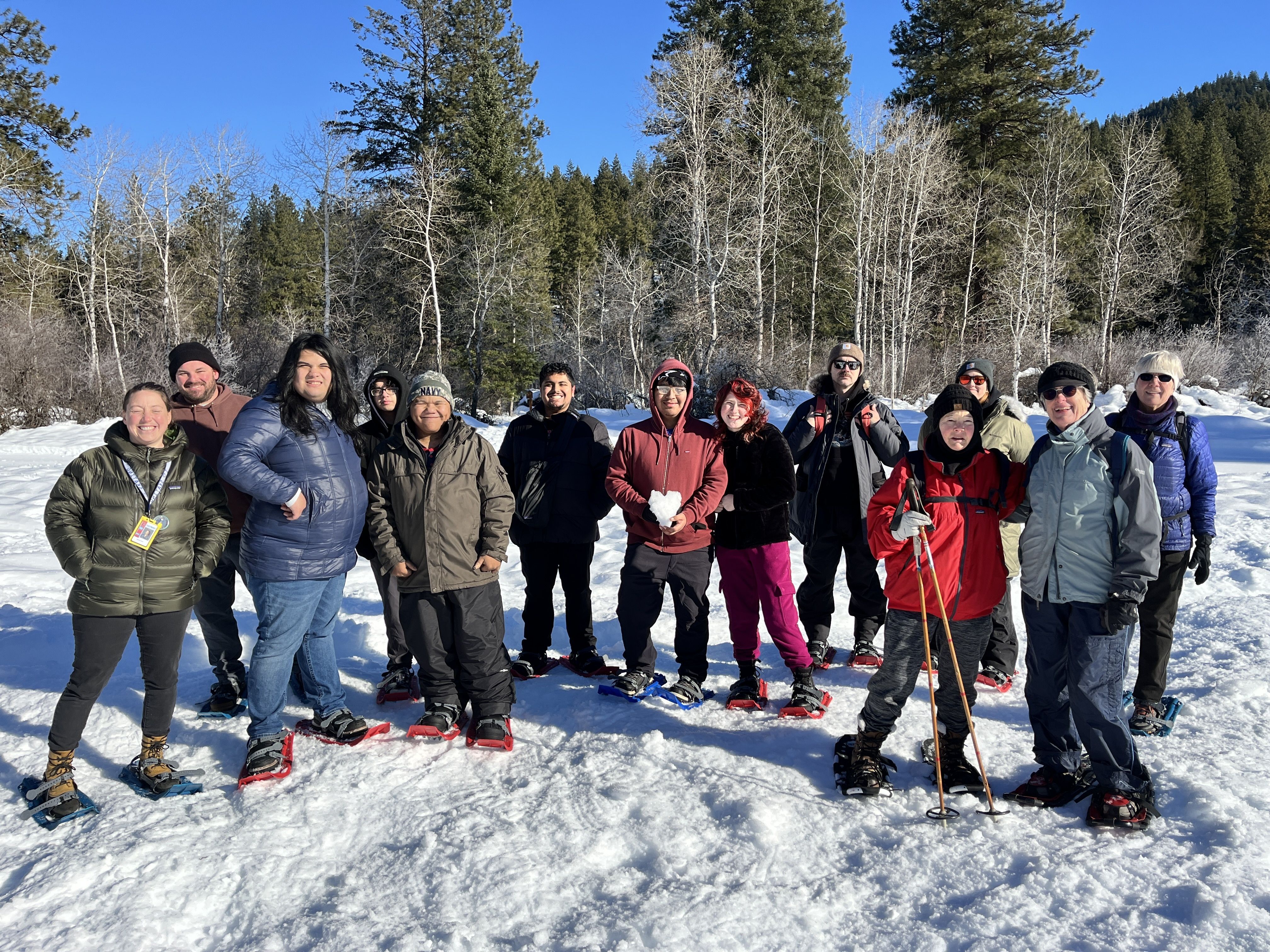 A photo of attendees snowshoeing at the Leavenworth National Fish Hatchery with trees in the background.