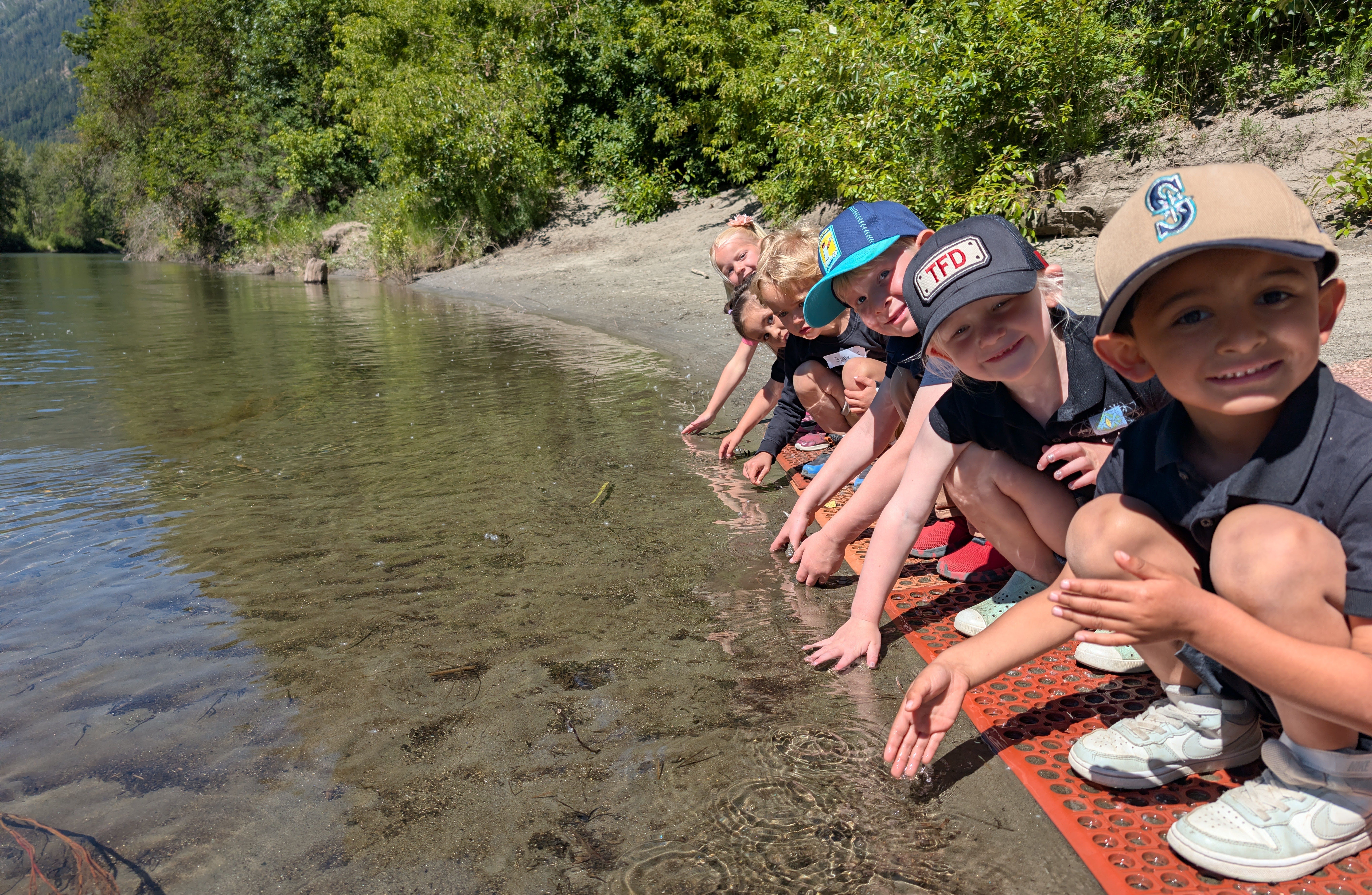 A group of young students on the shore of the Wenatchee River.