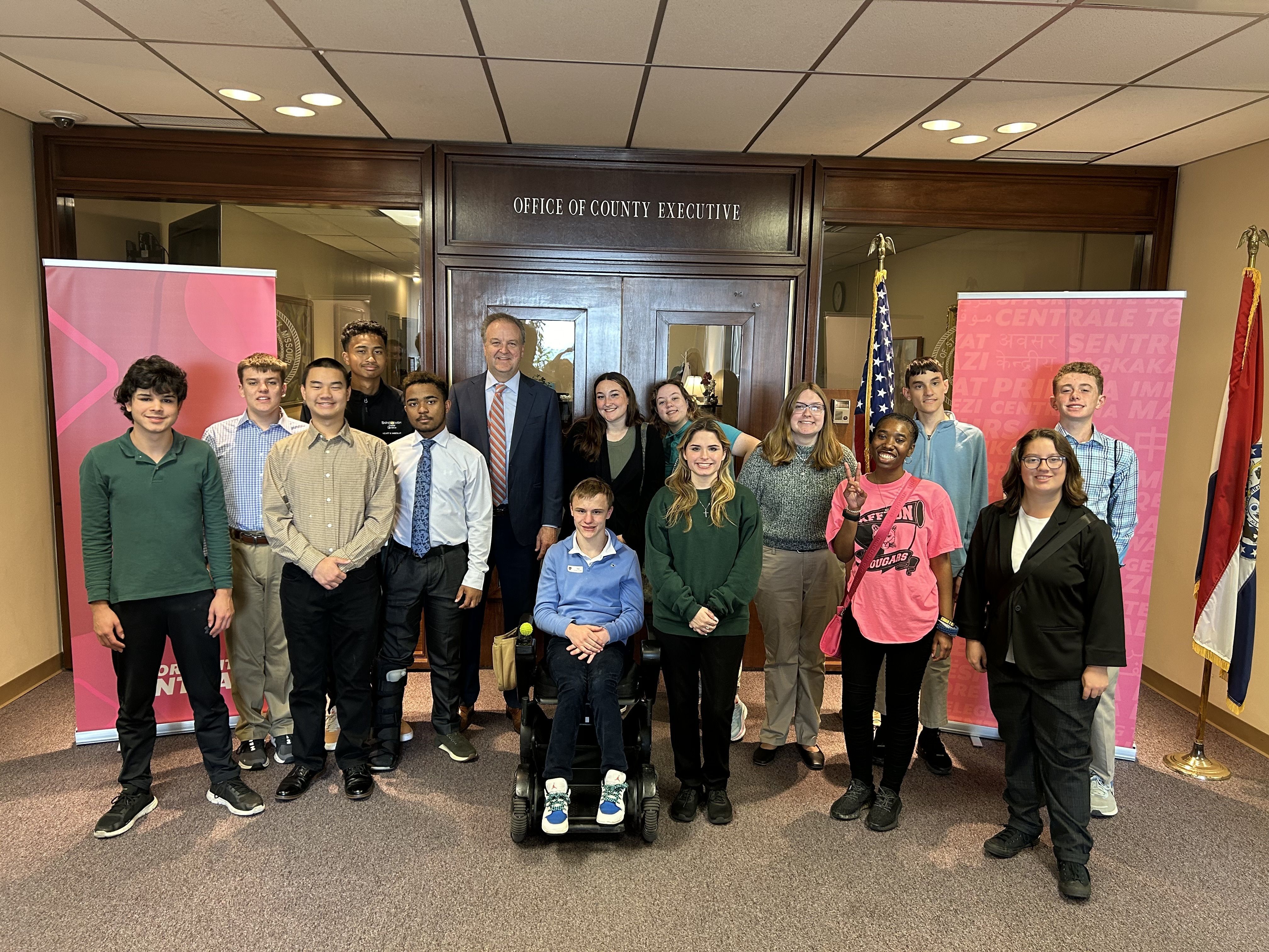 students standing with county executive Sam Page posing for a photo