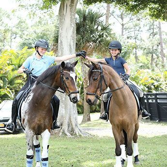 Two young girls riding horses.