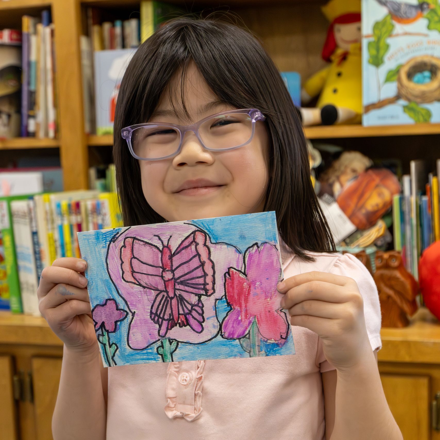 Excited student displaying colorful artwork from a Sunshine & Smiles kit