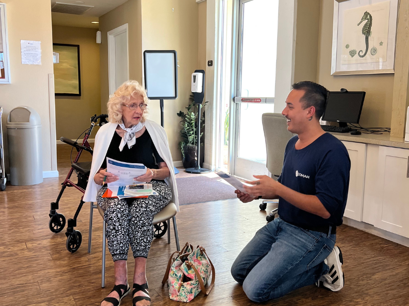 CEJA SOMAH Manager Tyler Valdes speaking with a resident about solar energy