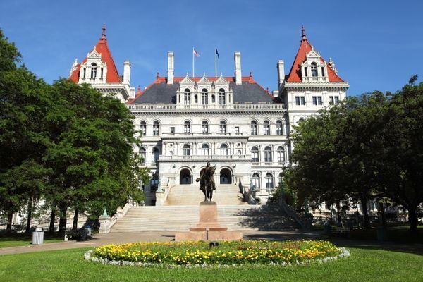 New York State Capitol with statue of Union Major General Philip Sheridan surrounded by spring flowers.