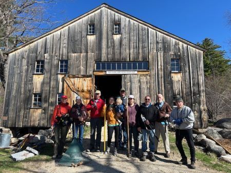 Volunteers help Tin Mountain stack wood to get ready for winter