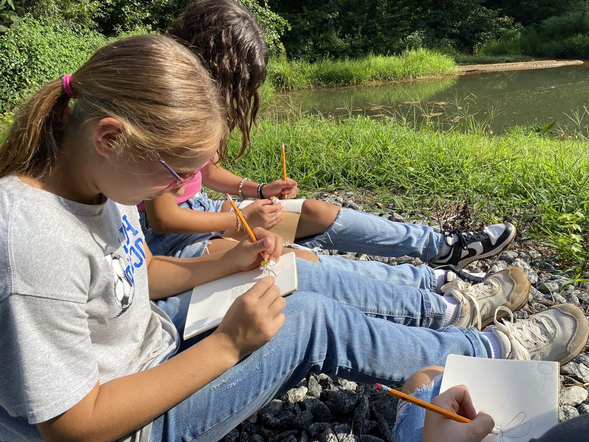 students reading in the grass