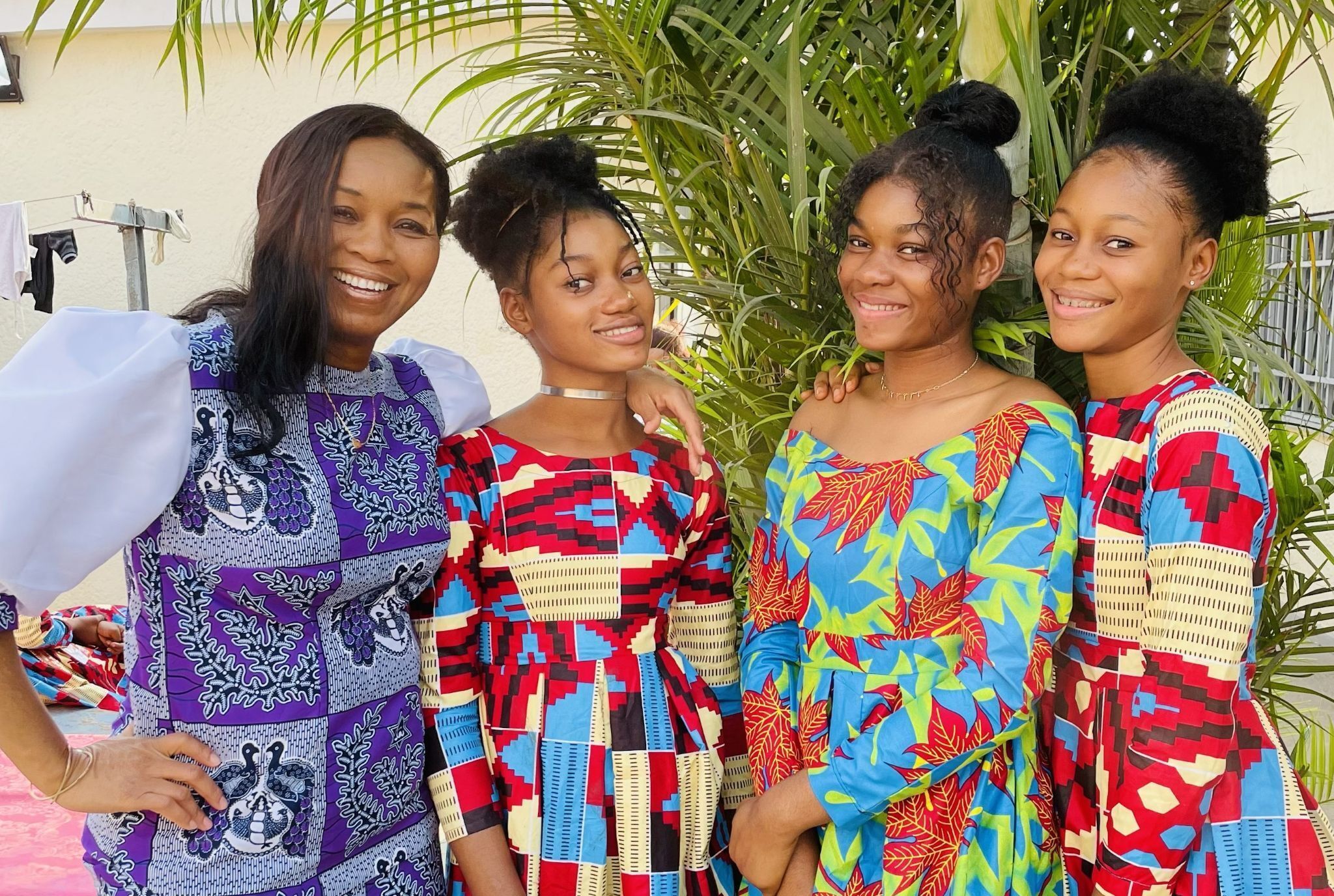 Four women in colorful dresses