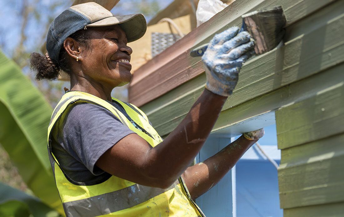 Woman painting the exterior of a house.