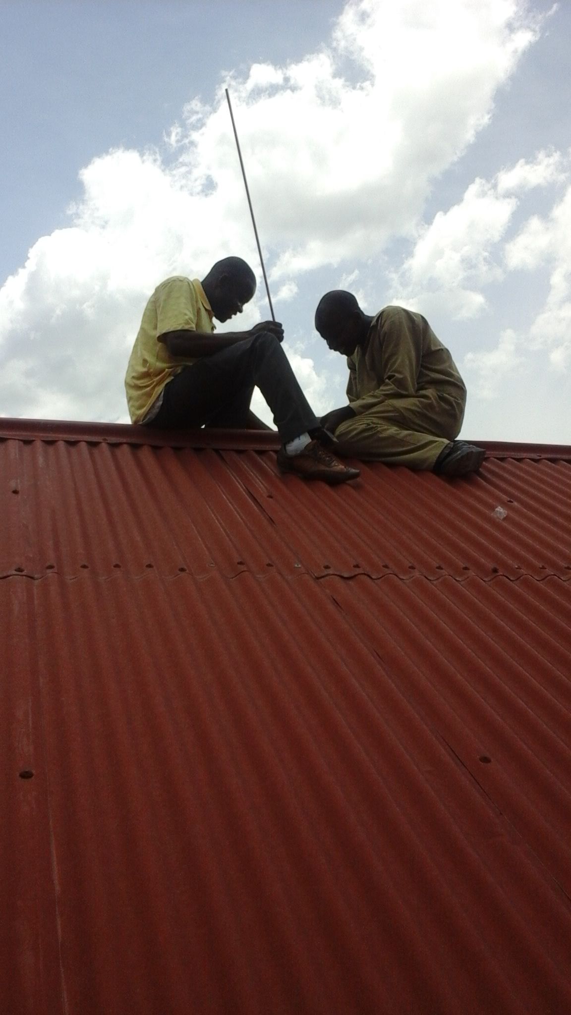 Installing lightning rods - called 'arrestors' by Ugandans