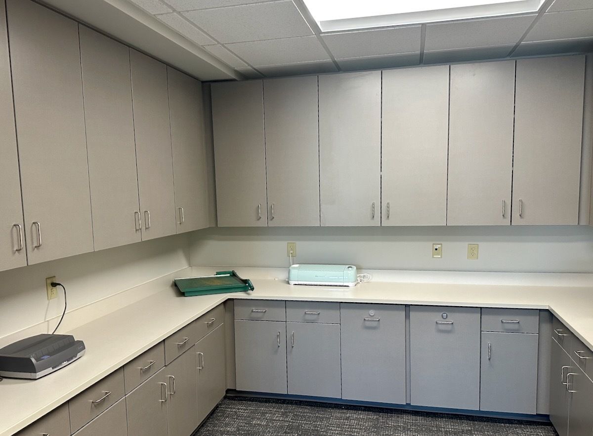 a photograph of ESU 1's office area with a paper cutter and a cricut machine