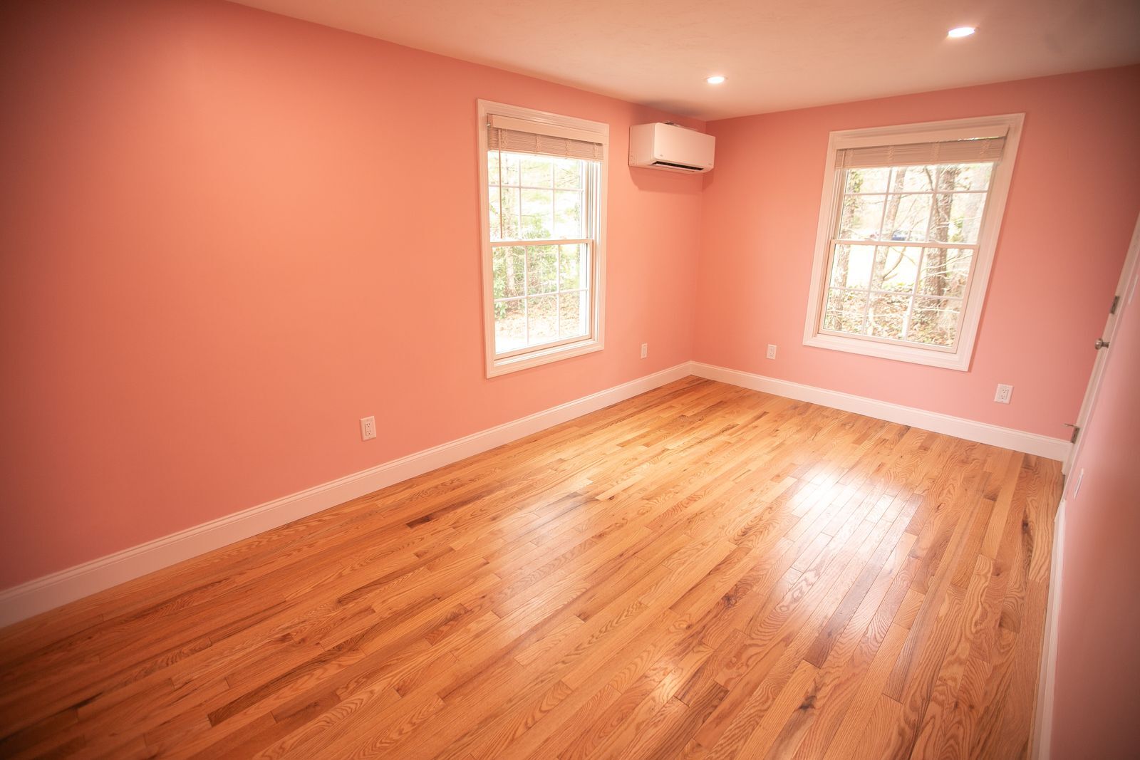 A photo of an empty bedroom with pink walls