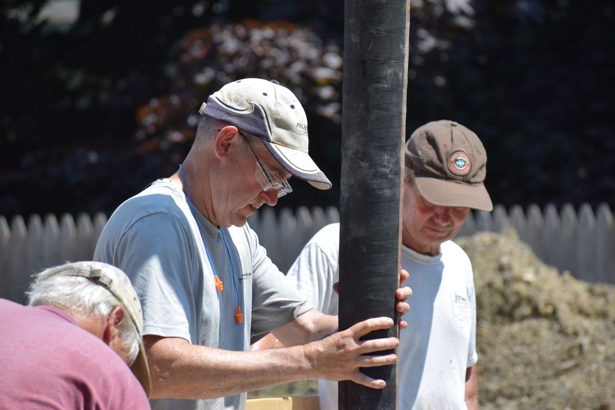 Volunteer holds the tube that is pouring concrete.
