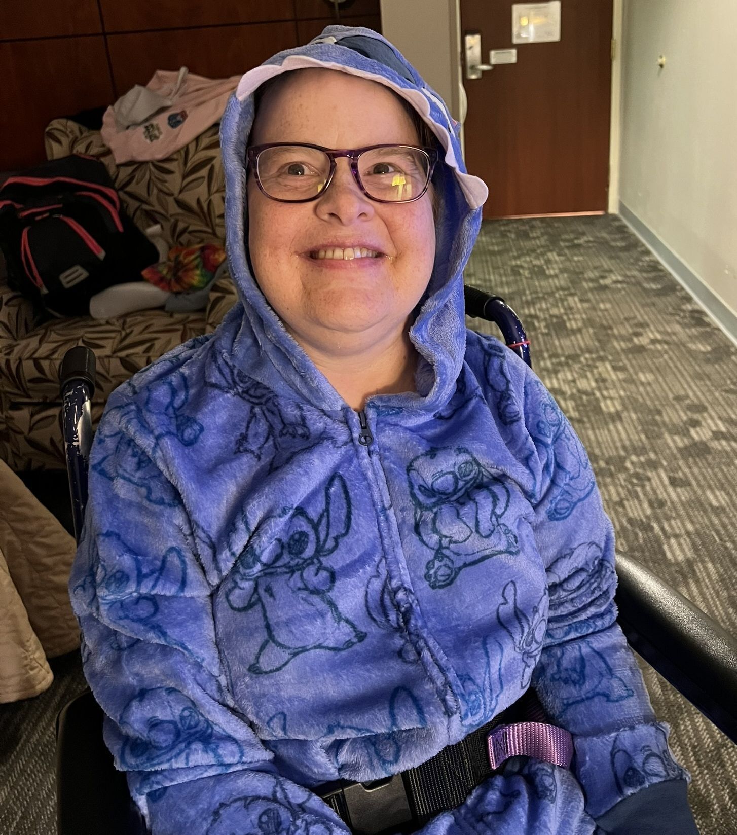 Amy wears hooded pajamas while sitting and smiling toward the camera