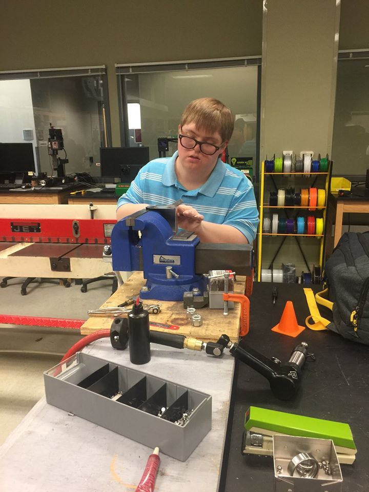 Student with down syndrome in machine shop classroom