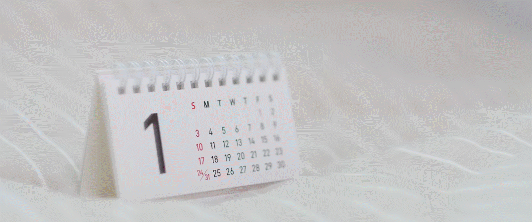 Image of a small calendar on a white tablecloth.