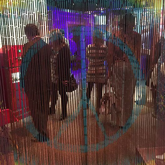 People standing behind a curtain with a peace symbol overlay.