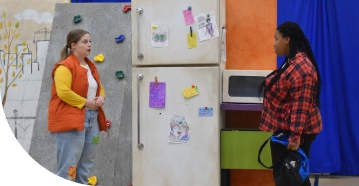 girls standing in front of a refrigerator in a play