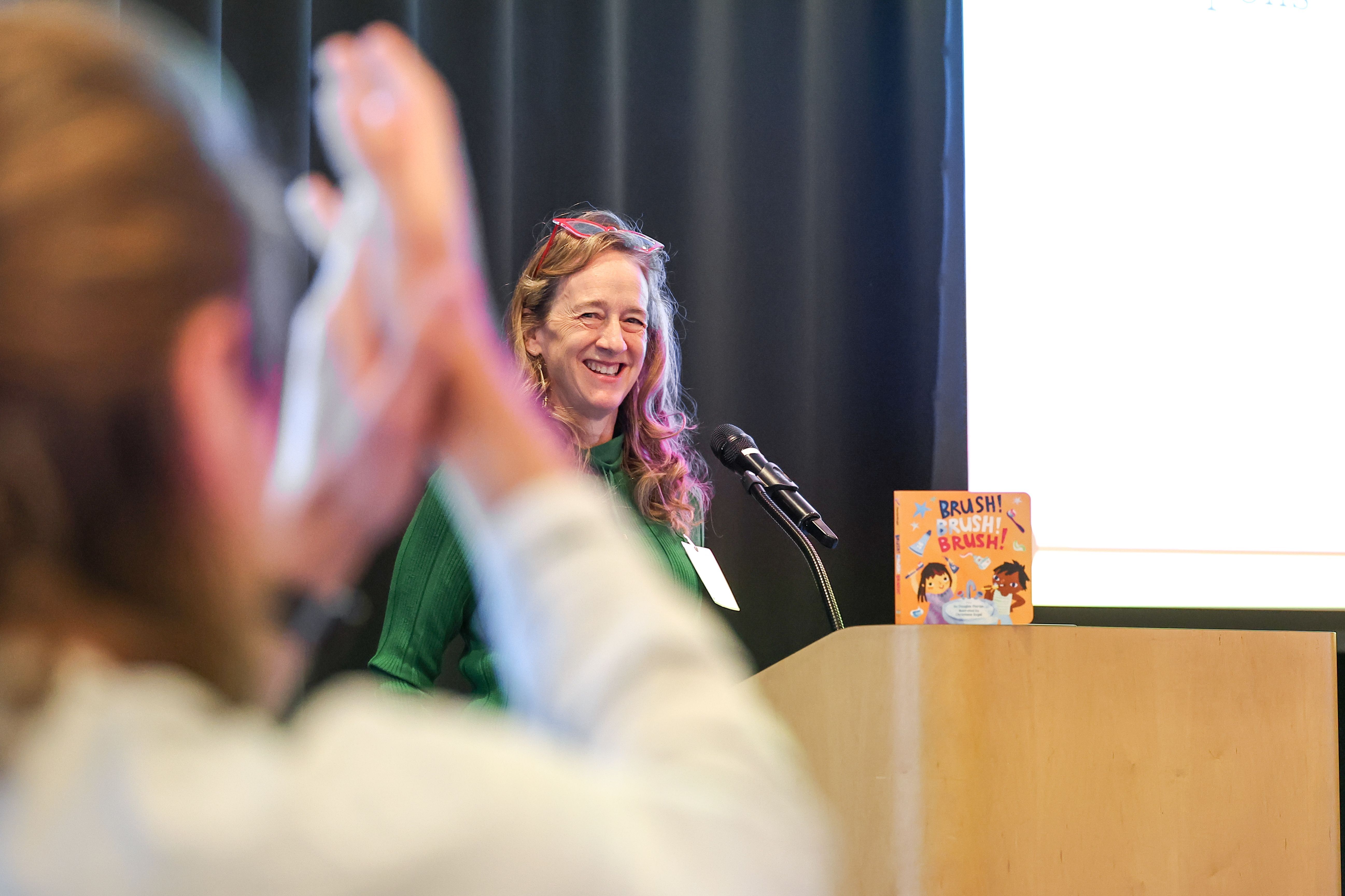 People at desk sign books and sell t-shirts to audience members