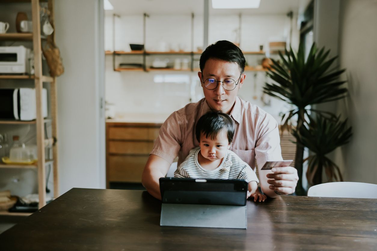 father and child shopping online on a laptop computer