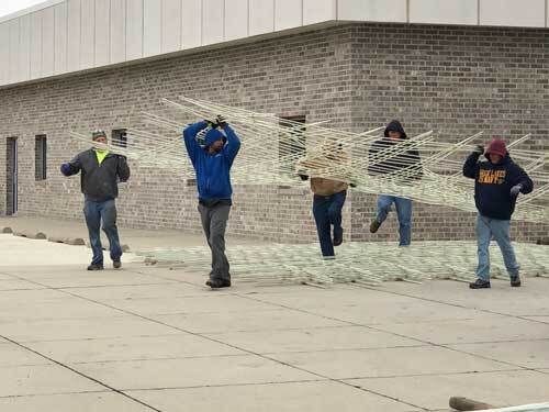 Workers carrying construction materials