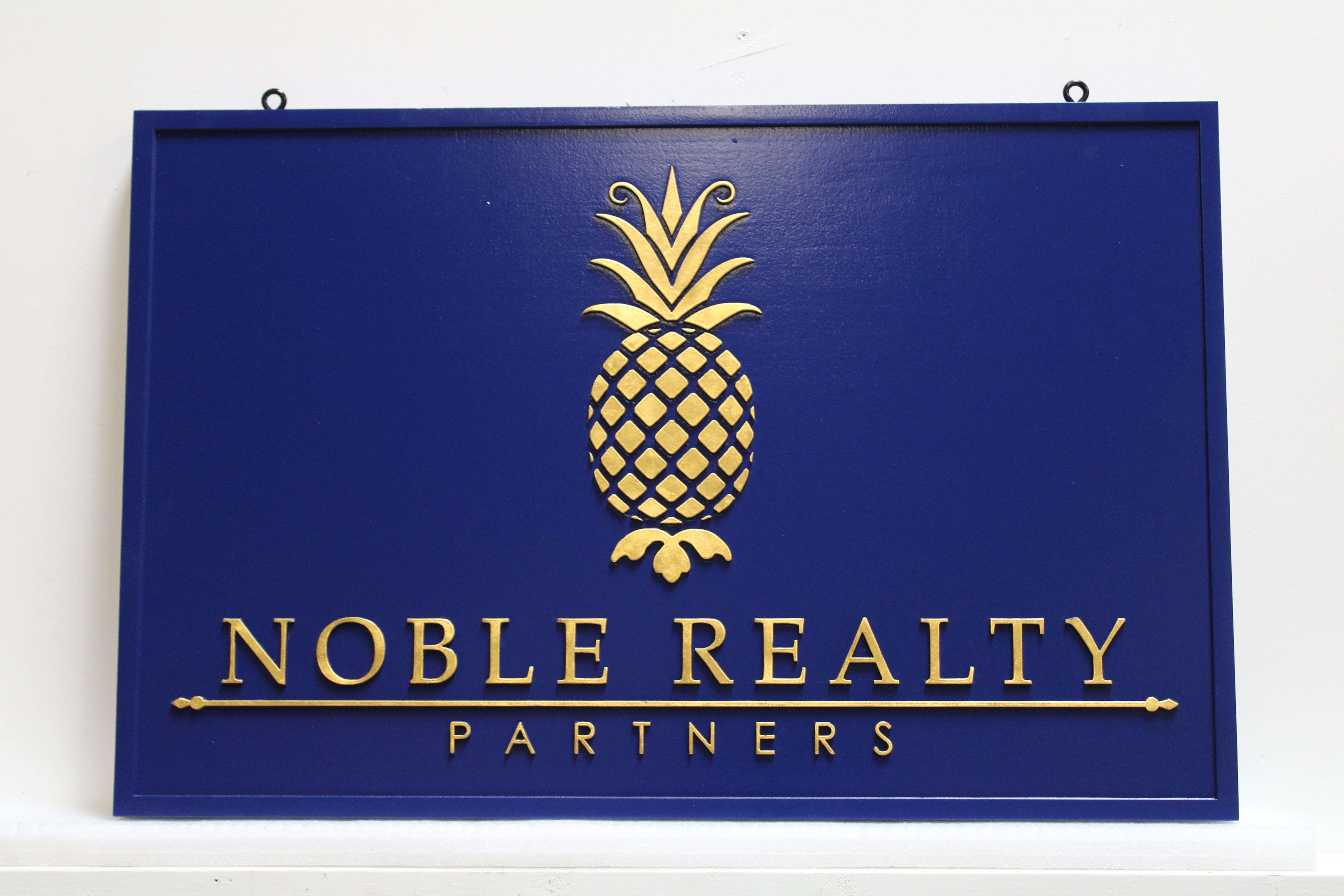 C12288 - Carved 24K Gold-Leaf Gilded  Raised Text and Pineapple  Sign for the Noble Realty Partners  