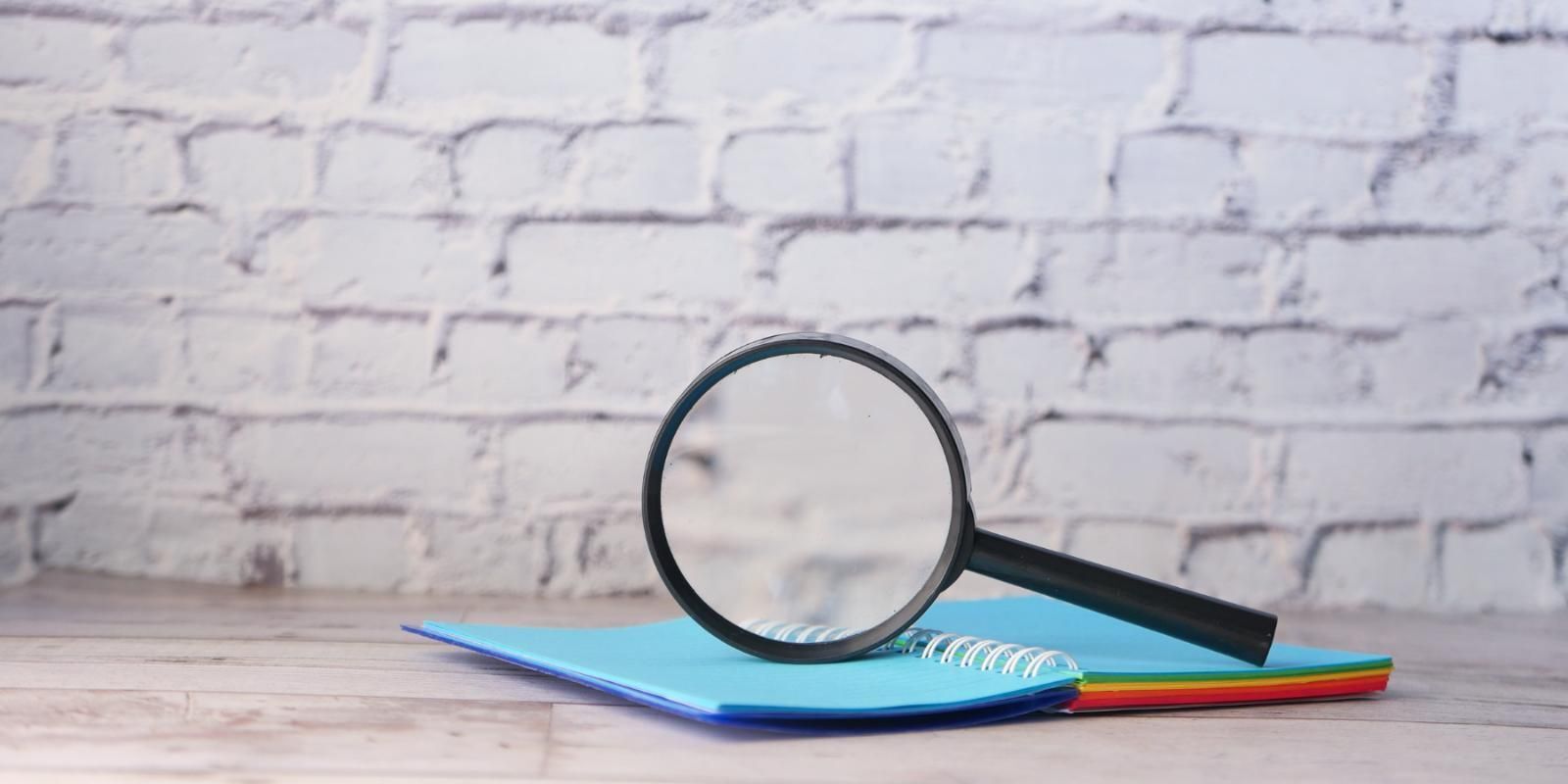 Magnifying glass balanced on an open book.