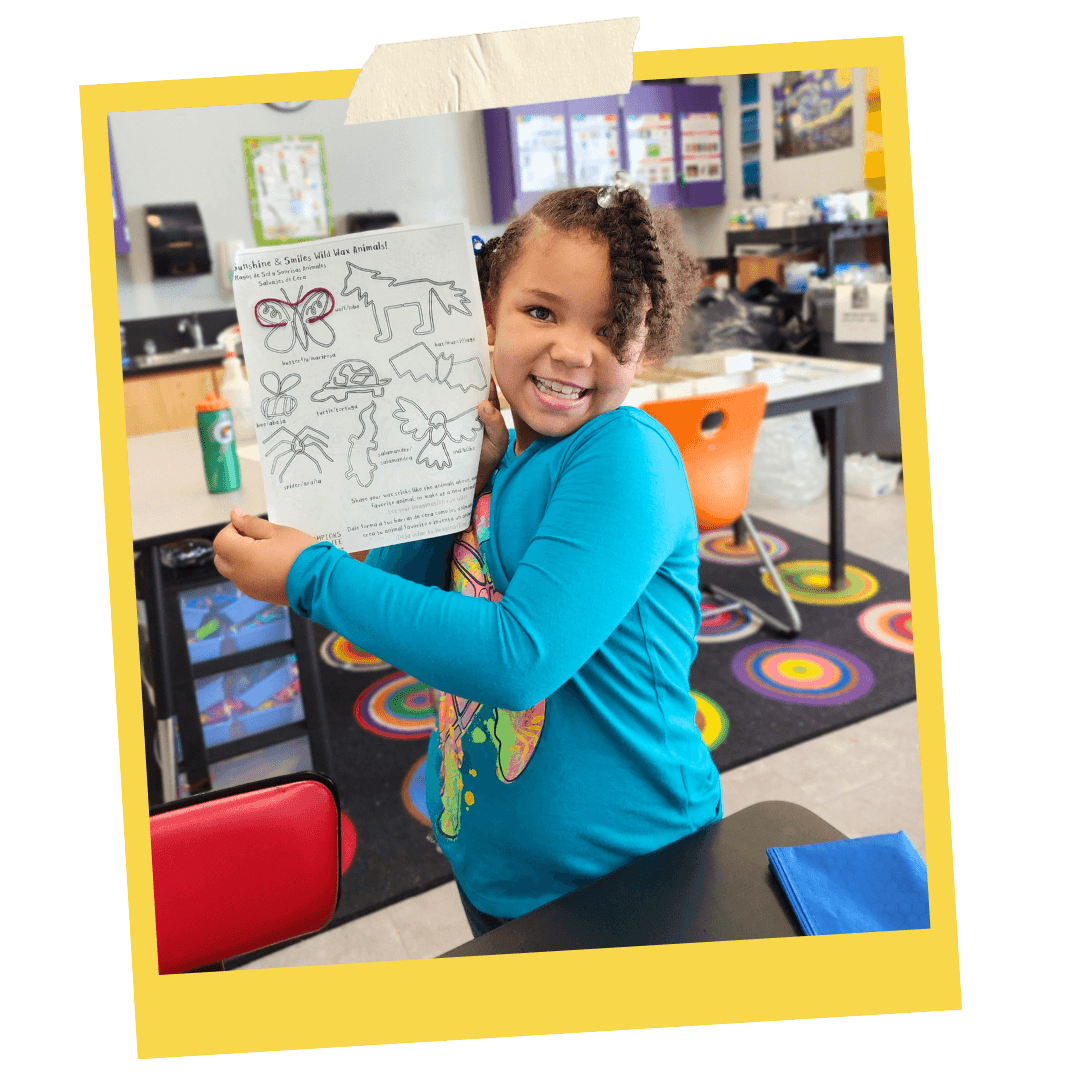 Excited student displaying artwork from a Sunshine & Smiles kit