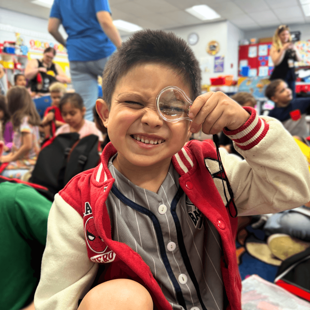 Young boy looking through a magnifying glass