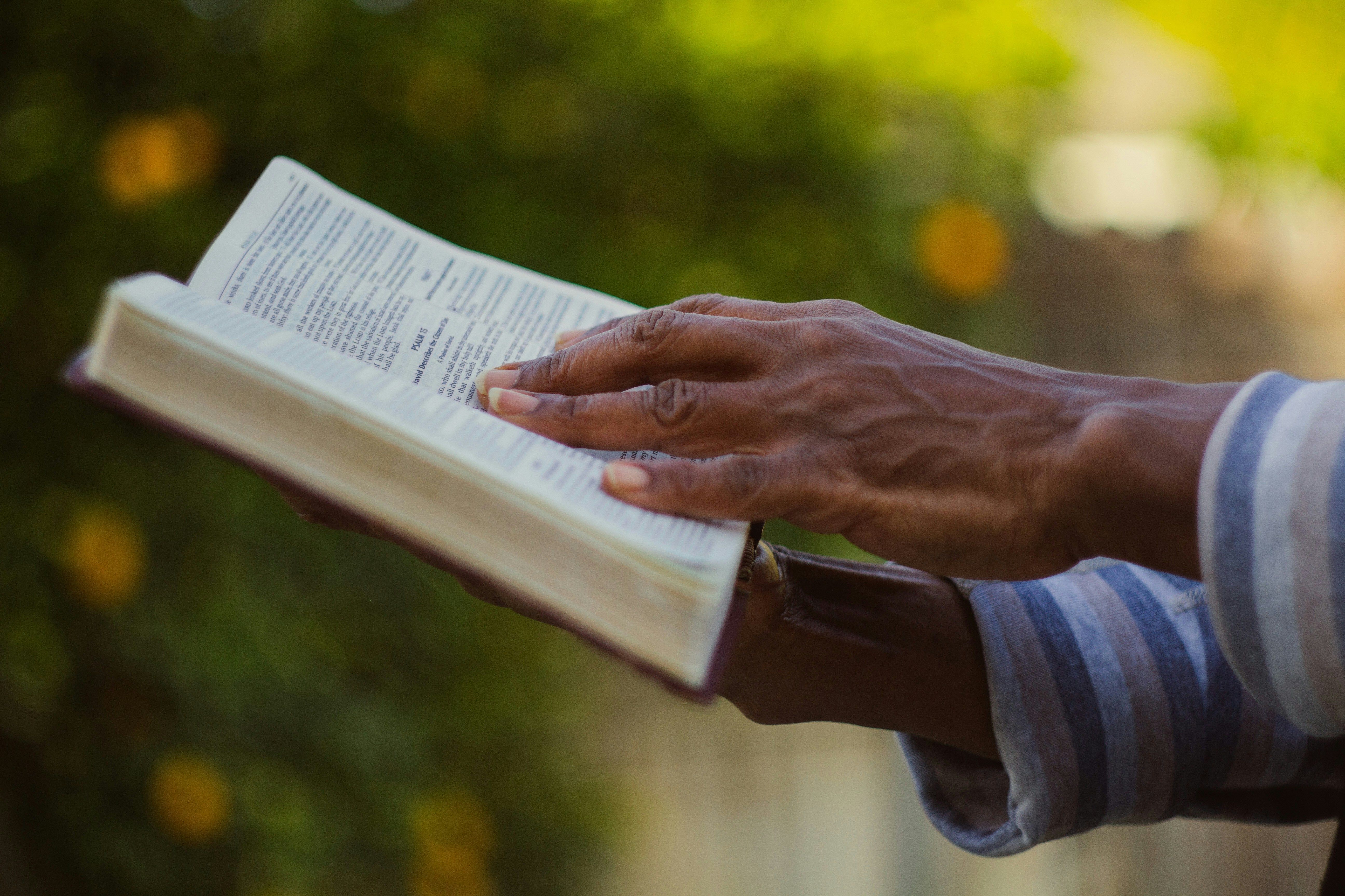 Photo of person holding a bible outside