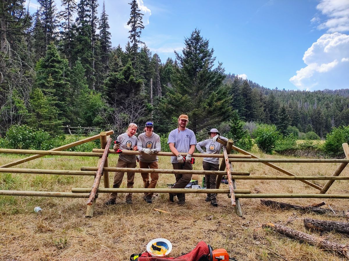 [Image Description: An MCC crew poses with a split log fence that they just built.]
