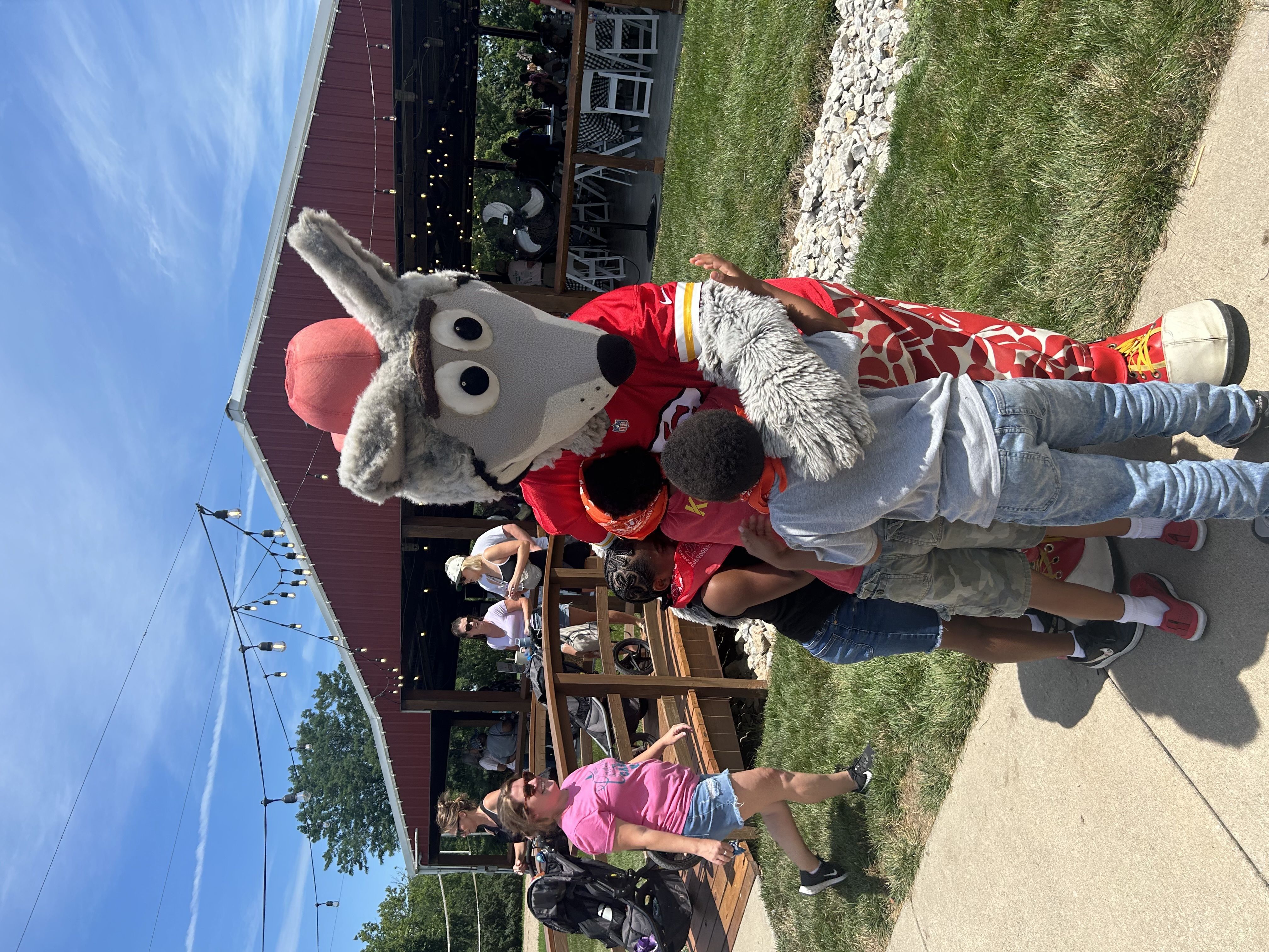 KC Wolf hugs children at Carnival