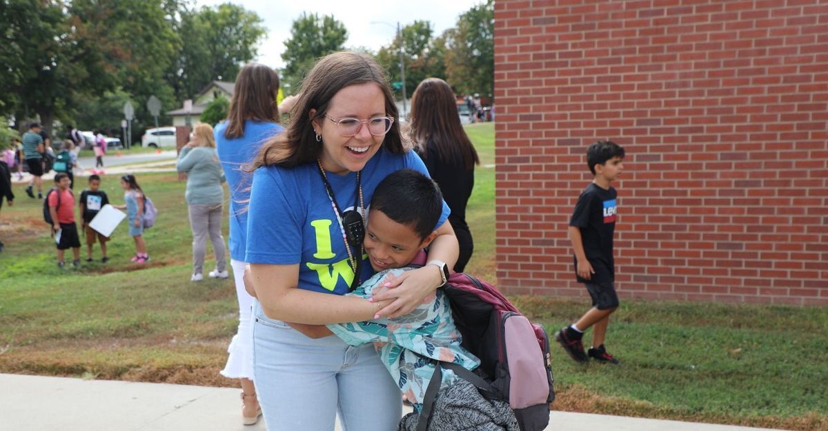 a teacher and student hugging outside 