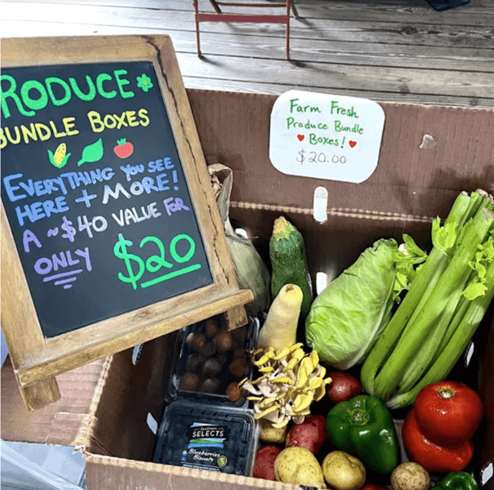 Boxed produce with chalkboard sign advertising $20 per box.