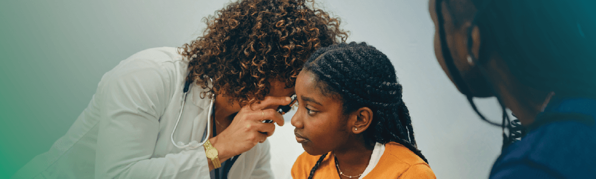 doctor checking ears of child patient