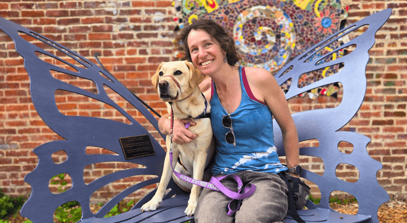 Christinia and Hearing Dog Danny on butterfly bench