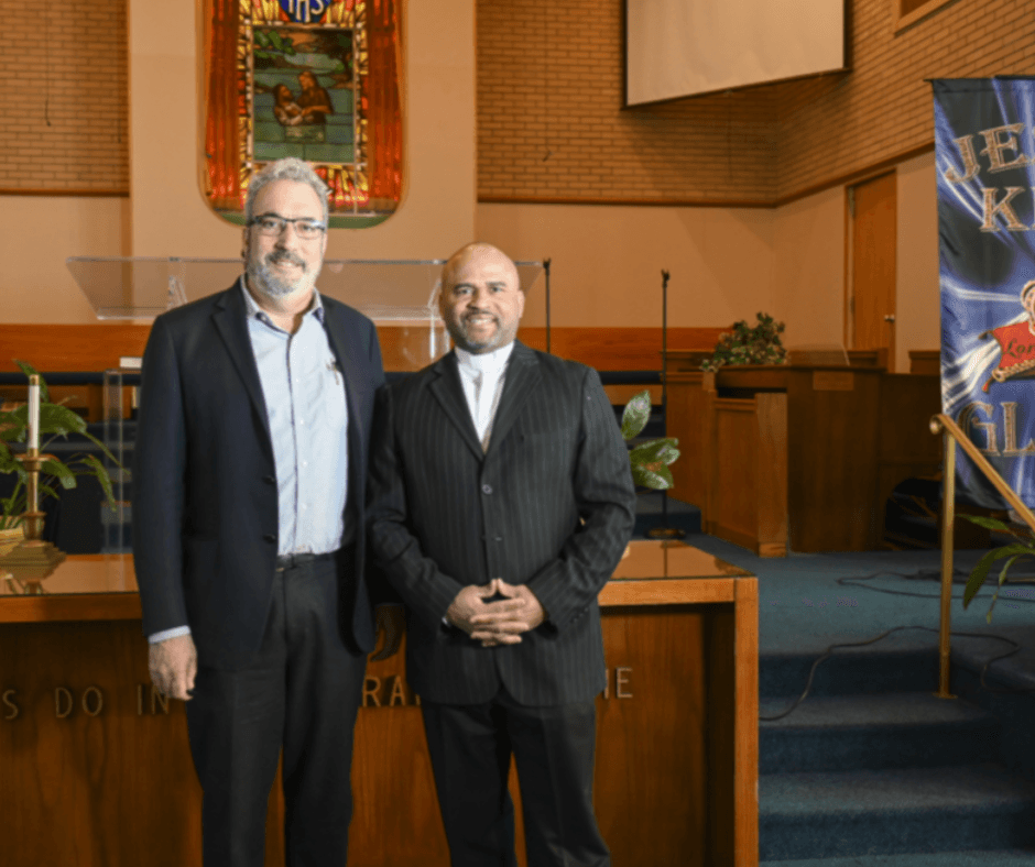 Rev. Darrell Armstrong stands at the front of the chapel with a representative from Systems for Action.