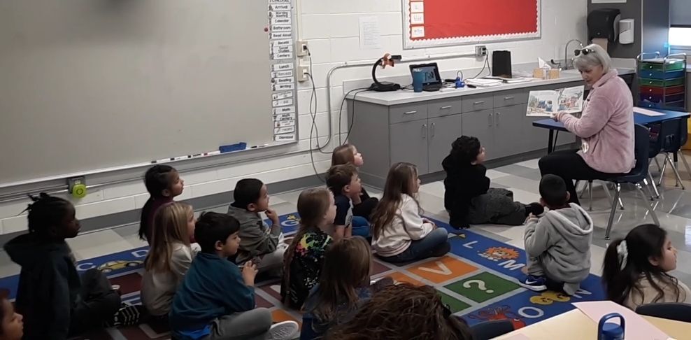 Liz Justice reads & gives books to Clarke Kindergarteners