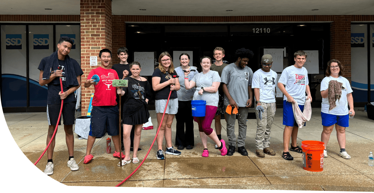 kids holding soap, sponges and hoses to wash cars