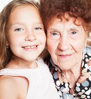 Grandmother and young granddaughter hug closely