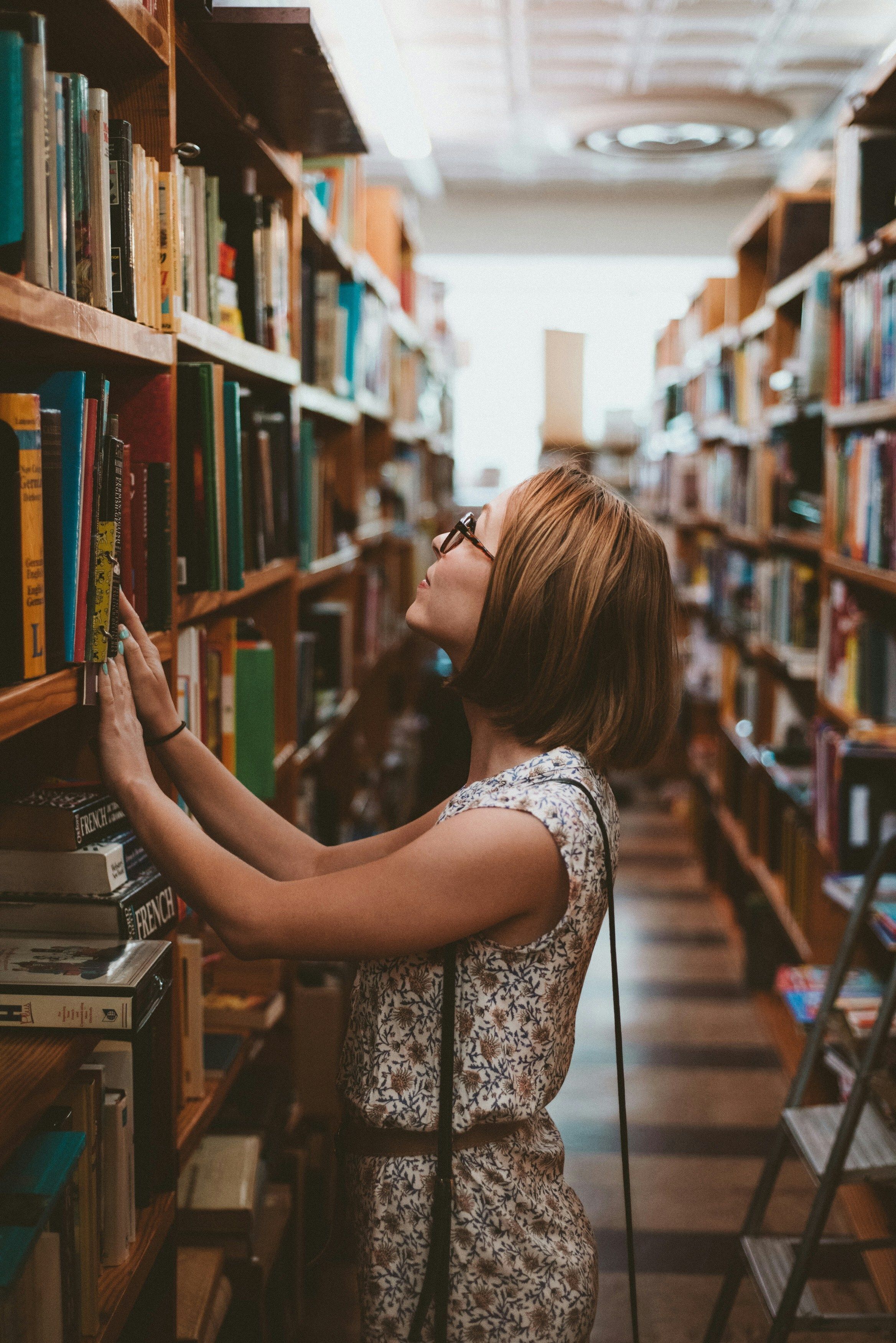 Women looking at book stack.
