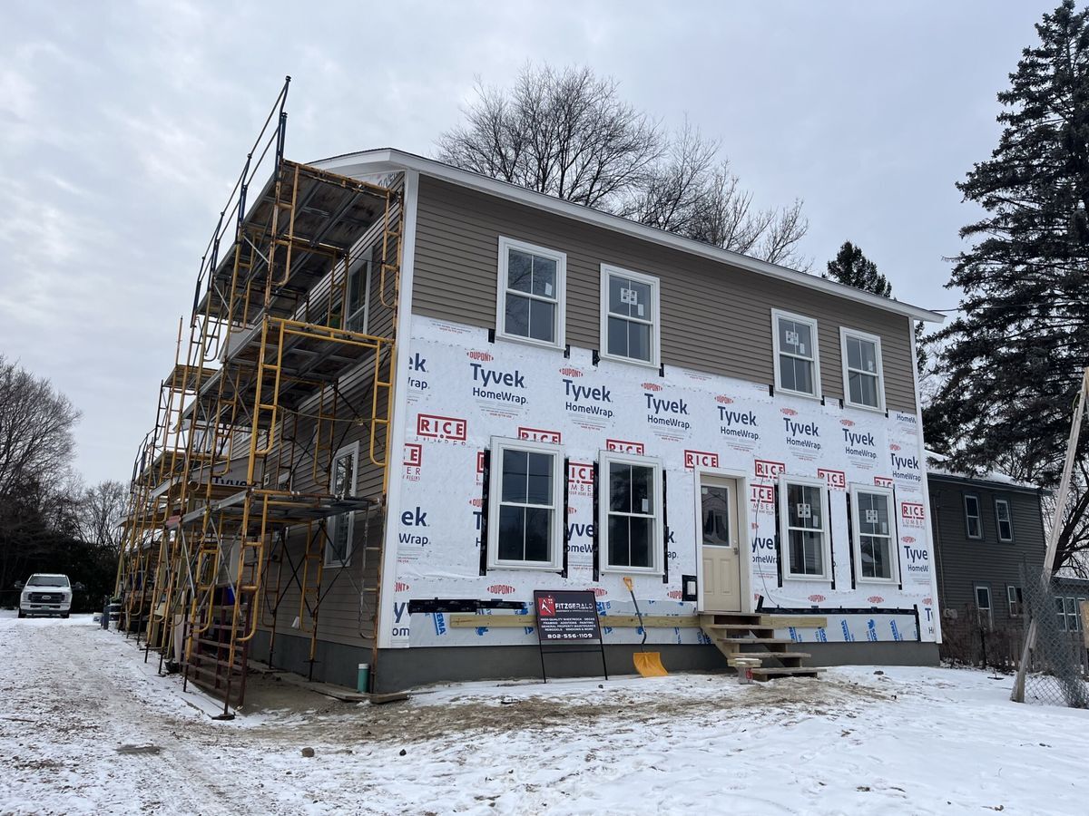 House with scaffolding and partial siding in the winter.