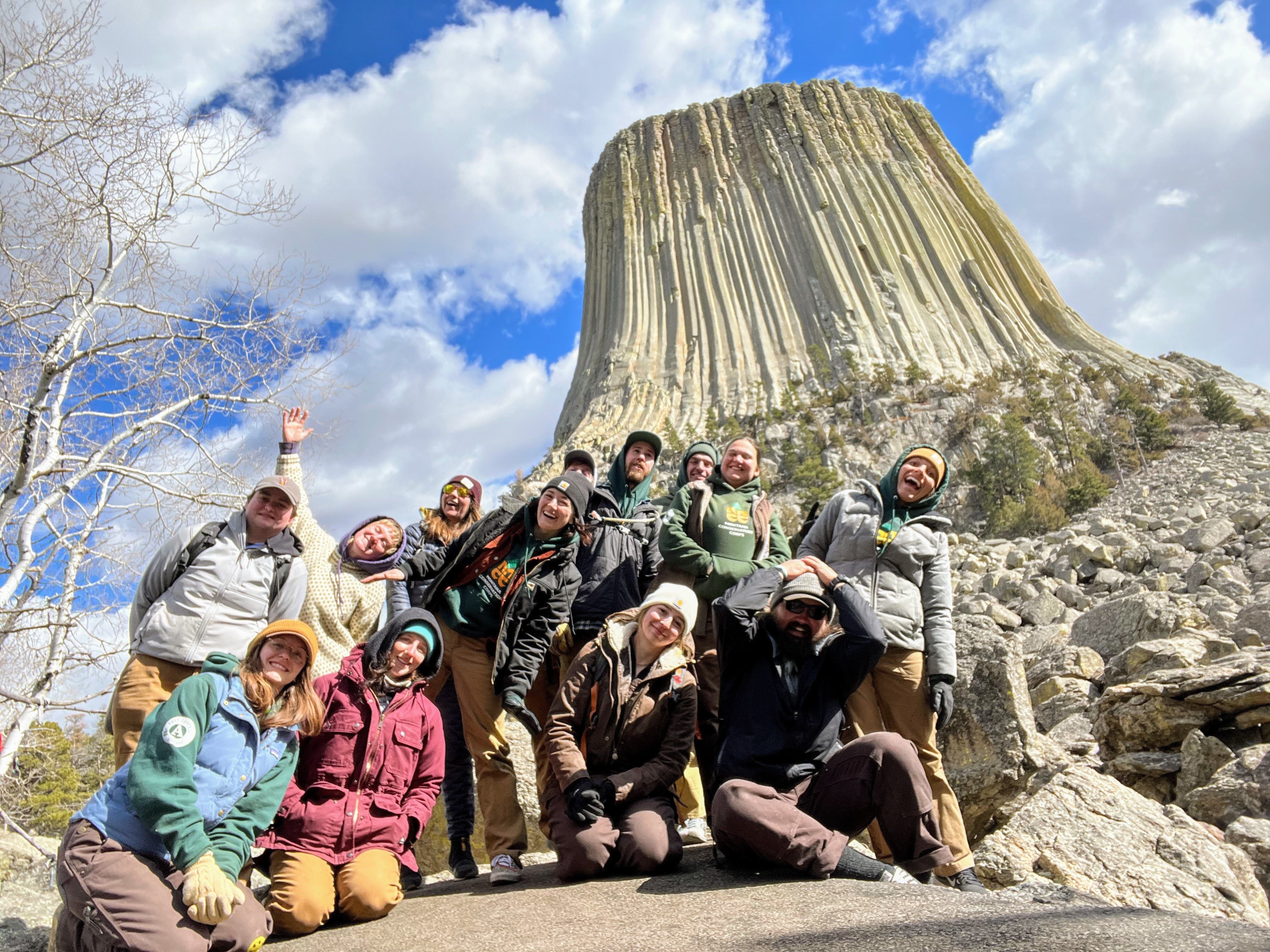 A group of crew leaders poses next to Devil's Tower in Wyoming