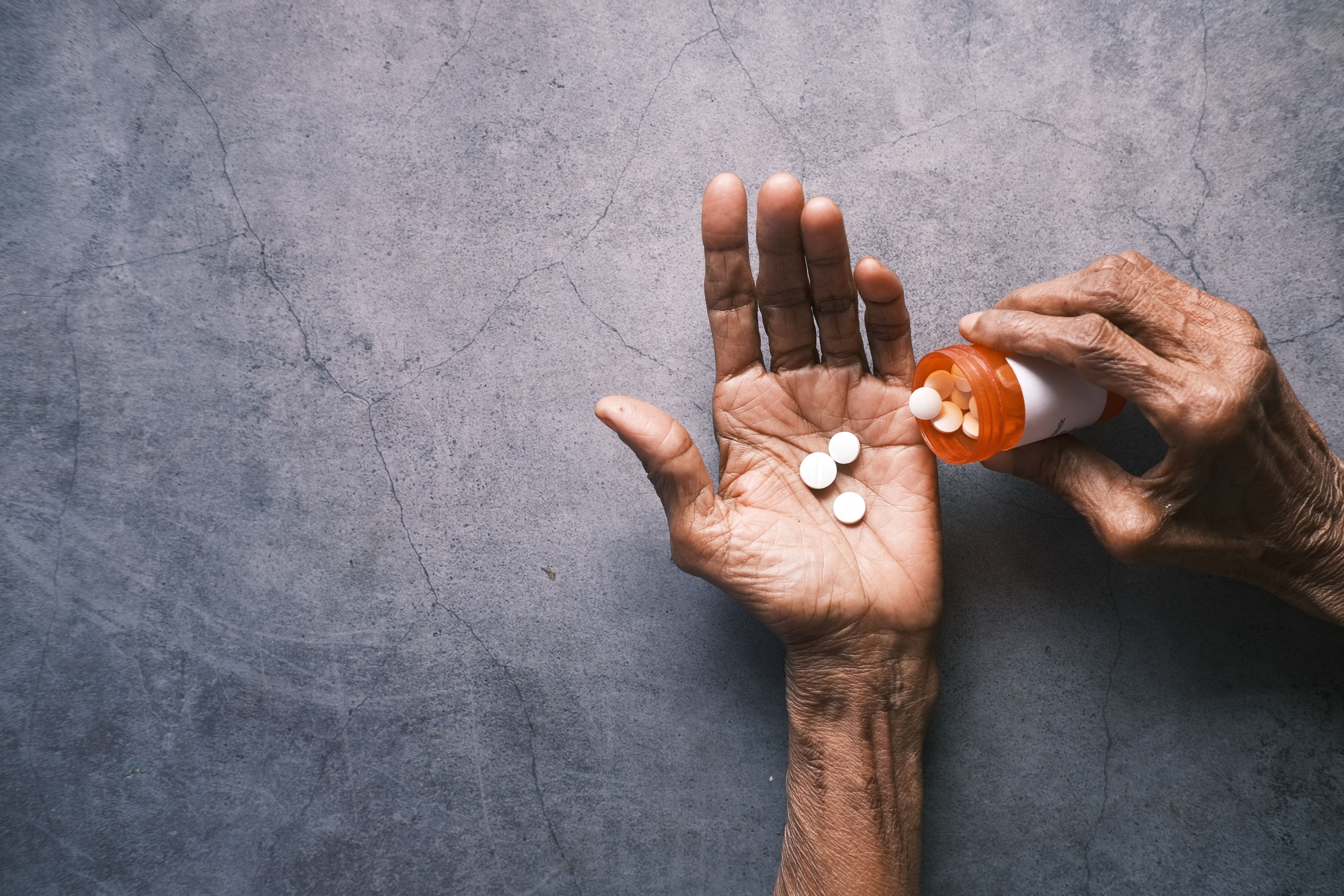 A hand with pills being poured into the palm