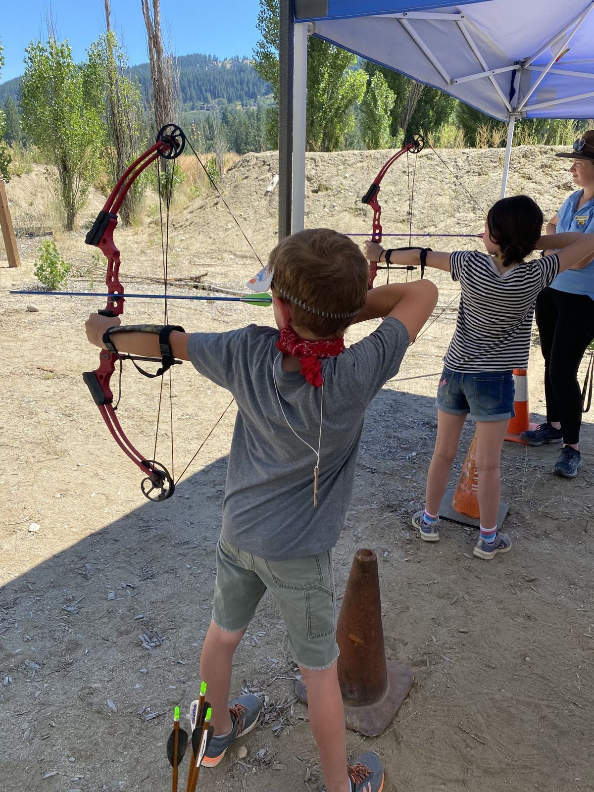 A student posed to shoot a bow and arrow during camp.