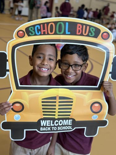 Mother holding her children's hands as they walk to school.