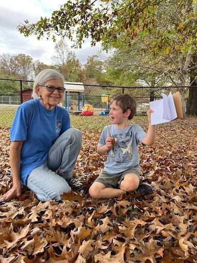 Volunteer helping a student fill out a page of their wildlife journal