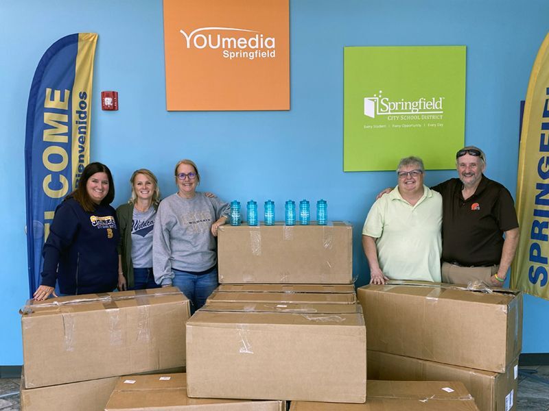 Donors stand with the water bottles they donated to Springfield City Schools.