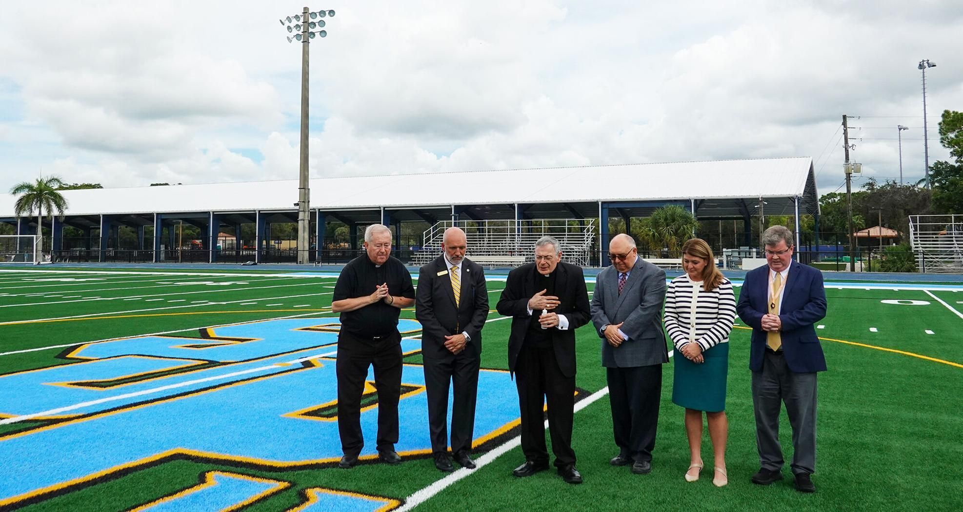 Bishop Gerald M. Barbarito prays at the Sept. 4, 2025, blessing of the high school's field, along with, from left, Msgr.  diocesan Superintendent Gary Gelo, Katie Kervi, assistant superintendent, and John Clarke, associate superintendent.