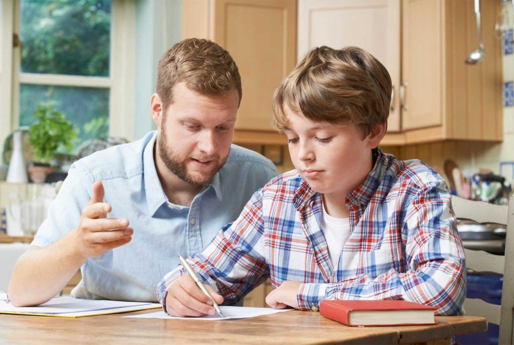 Photo of a father helping his son with his school work.