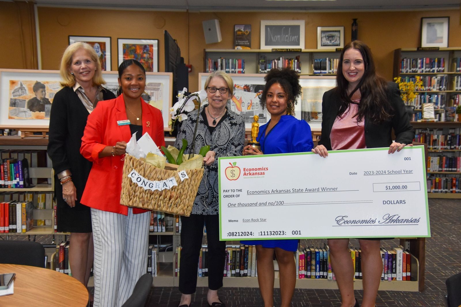 group of adults presenting large check and award to teacher